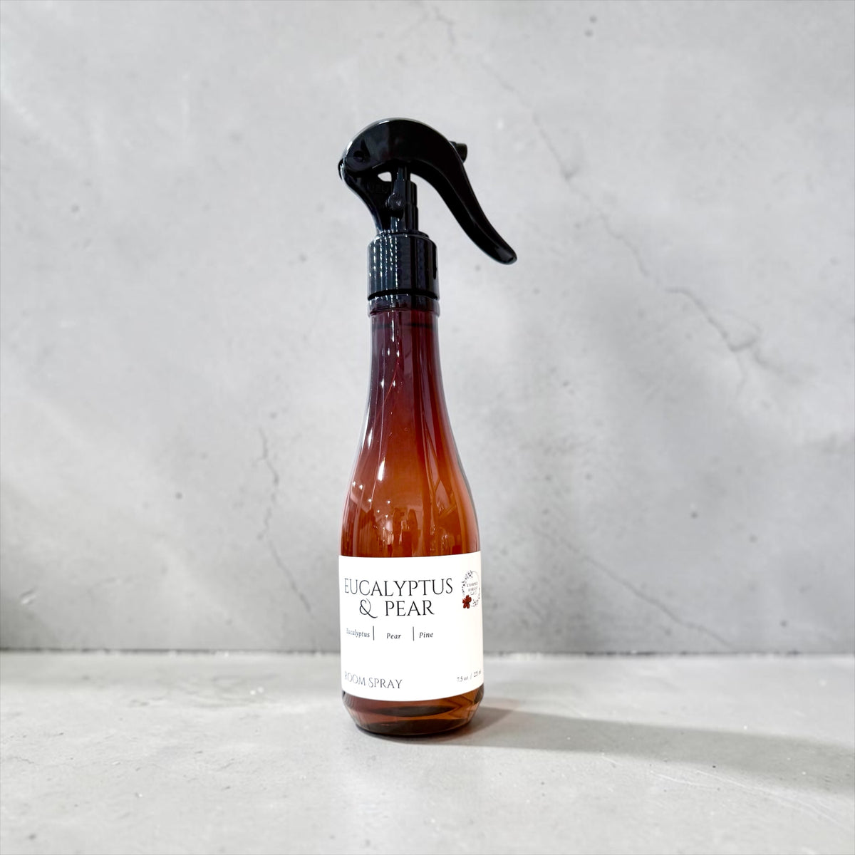 Eucalyptus & Pear room spray bottle on a plain gray background