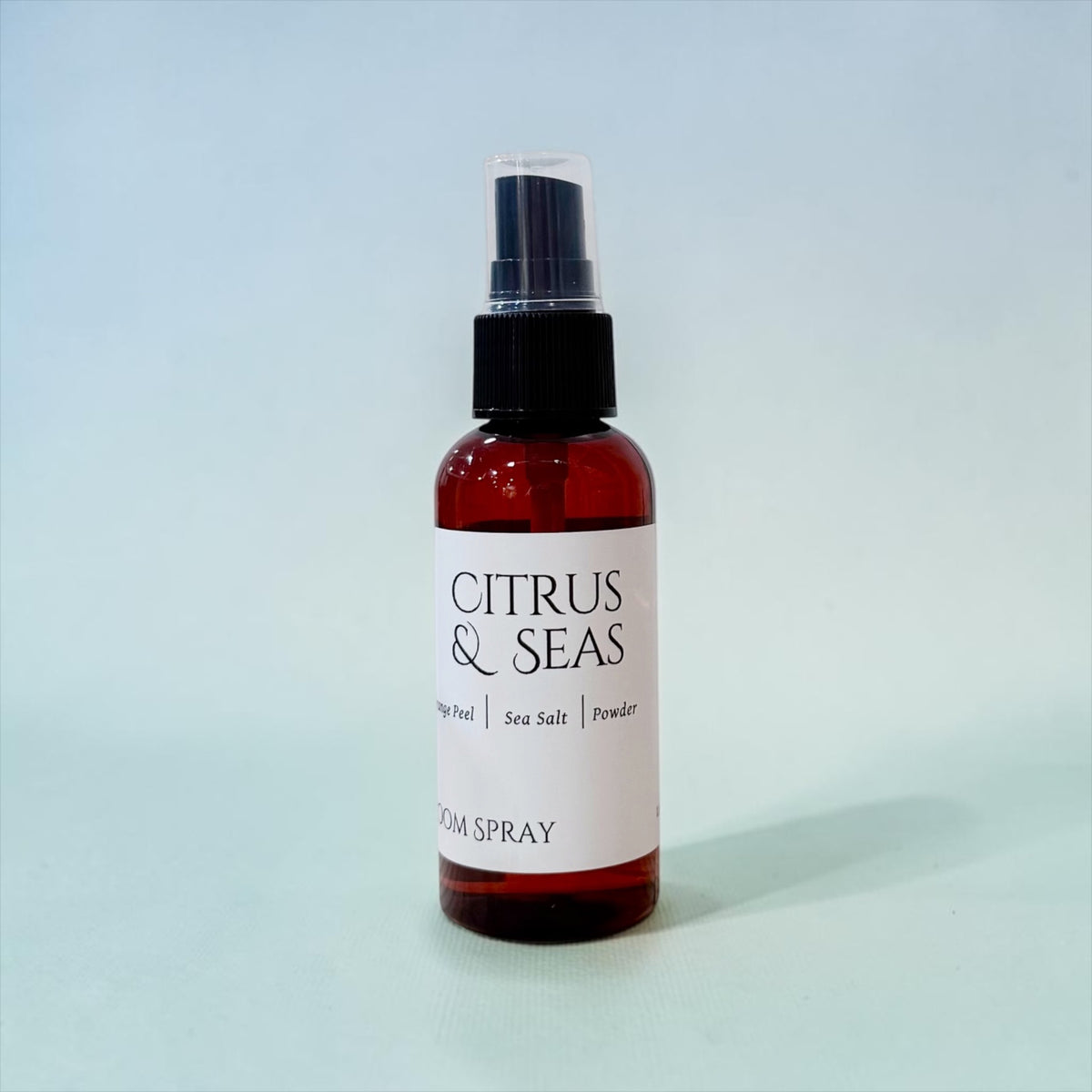 Citrus & Seas room spray bottle with pump top against a soft blue background