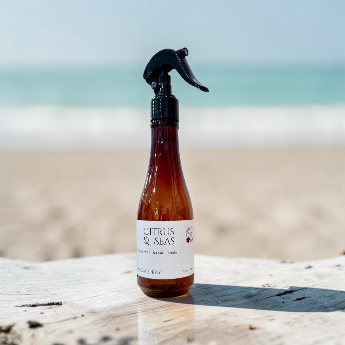 7.5 oz Citrus & Seas trigger spray bottle on a driftwood table by the ocean