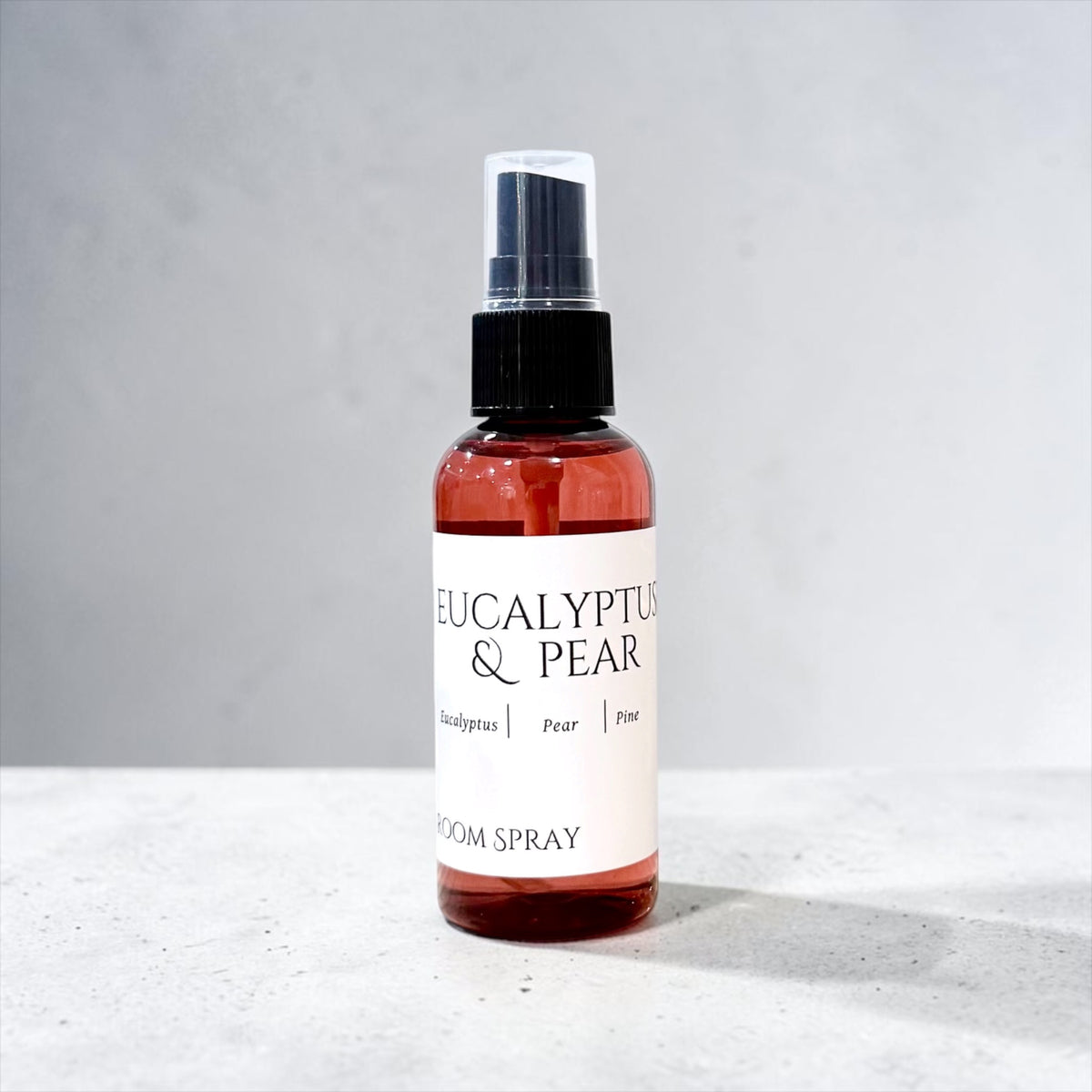 Eucalyptus & Pear room spray bottle on a soft gray background