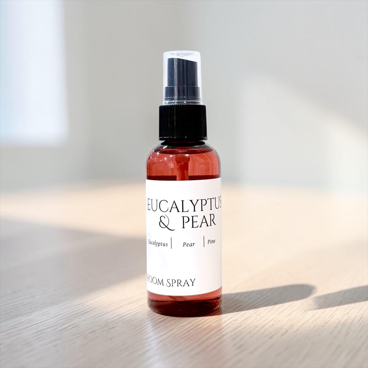 Eucalyptus & Pear room spray bottle on a wood table