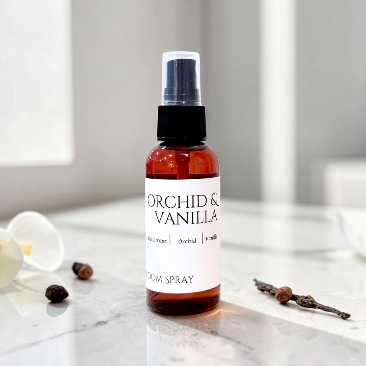 Orchid & Vanilla room spray bottle with vanilla bean pods on marble