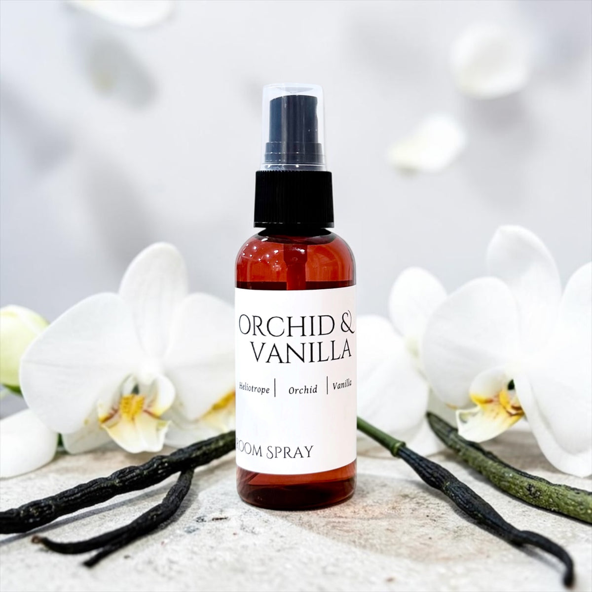 Orchid & Vanilla room spray bottle with a vanilla bean pod on marble