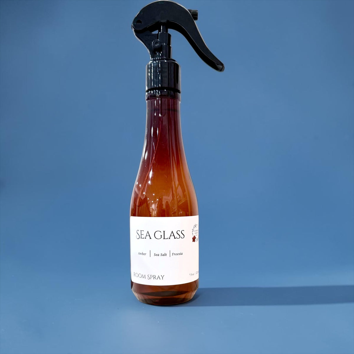 Sea Glass room spray bottle against a solid blue background