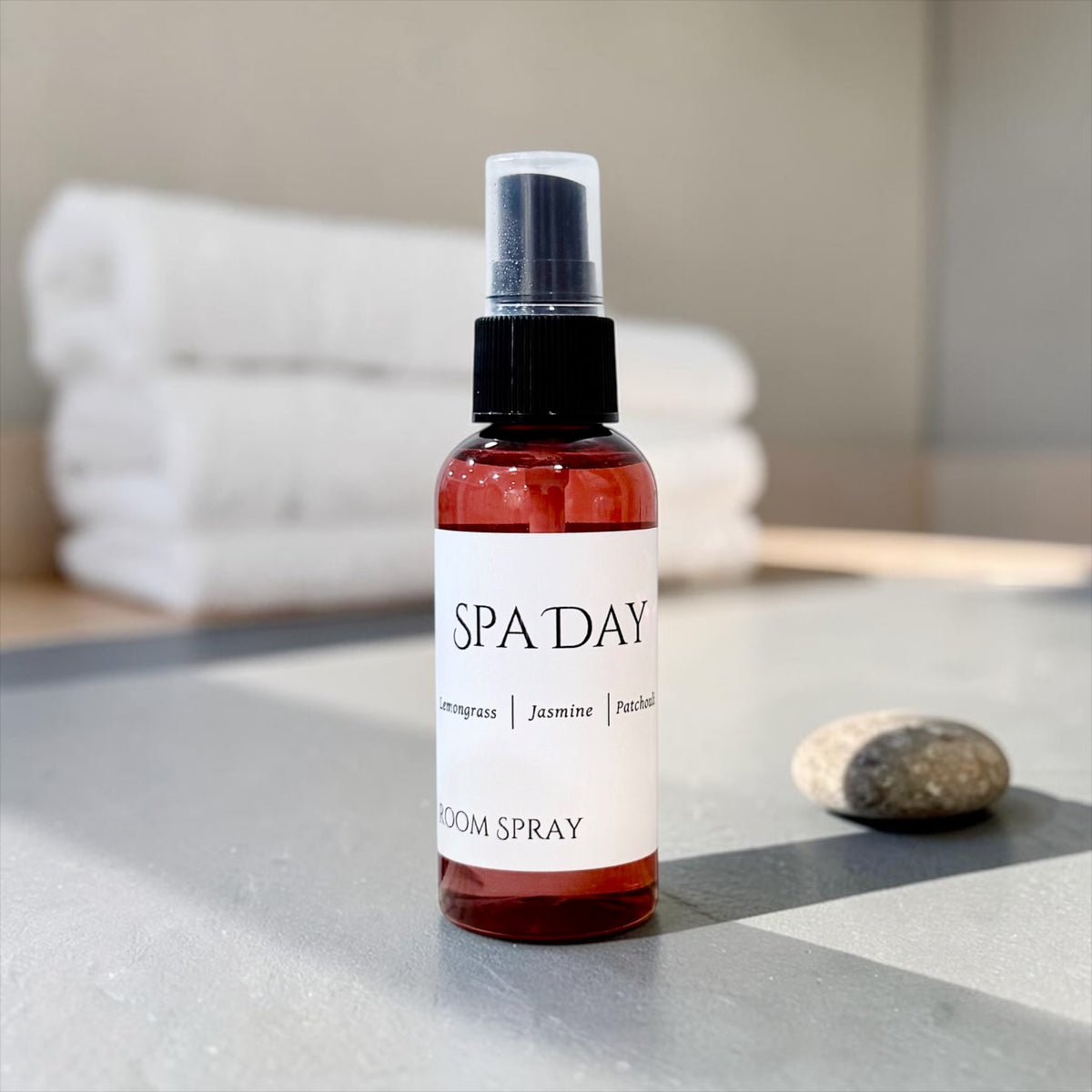 Spa Day room spray bottle with a white towel and river stones