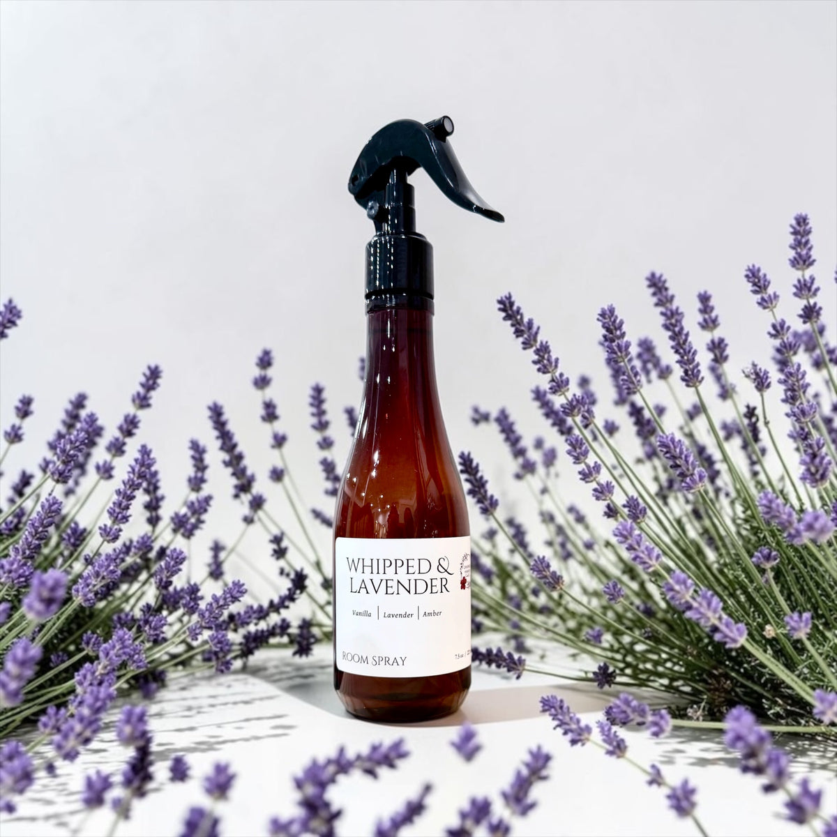 Whipped Lavender room spray bottle close-up with fresh lavender sprigs