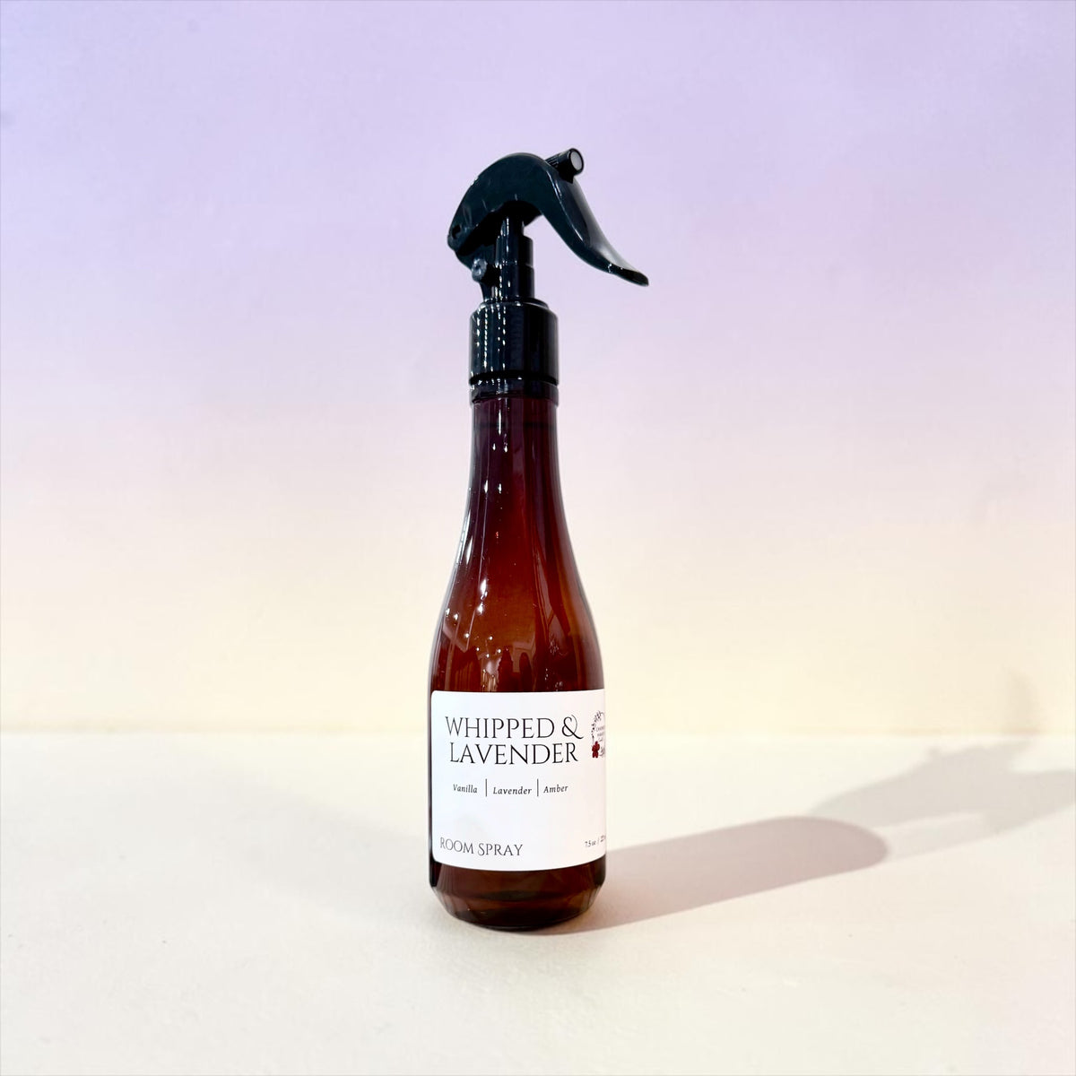 Whipped Lavender room spray bottle against a soft pink background